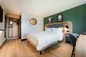 グラディニャンにあるカンパニール ボルドー シュド - グラディニャン タランスの緑の壁のベッドルーム1室(白いベッド1台付)