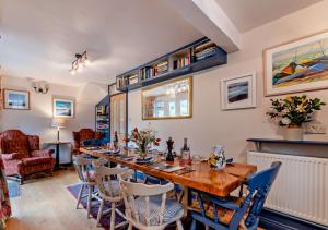 una sala da pranzo con un lungo tavolo e sedie di Devon Cottage - Fittleworth a Fittleworth