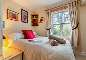 a bedroom with a large bed with a window at Devon Cottage - Fittleworth in Fittleworth