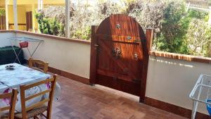 a large wooden door on a wall next to a table at Studio with shared pool terrace and wifi at Sciacca in Sciacca