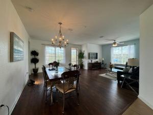 comedor y sala de estar con mesa y sillas en Vista Cay Getaway Luxury Condo by Universal Orlando Rental en Orlando