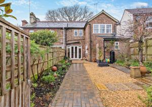 a brick house with a fence and a brick walkway at Devon Cottage - Fittleworth in Fittleworth