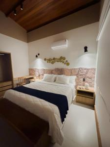 1 dormitorio con 1 cama grande y TV en Villa Hortensia, en Mucugê