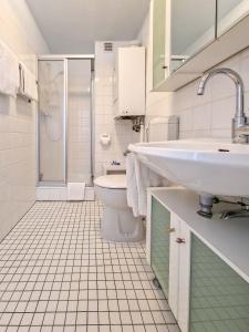 een witte badkamer met een wastafel en een toilet bij Moin in Greetsiel