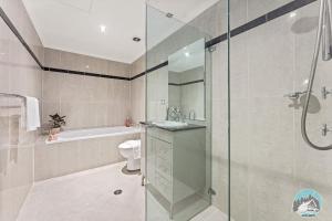 a bathroom with a shower and a toilet and a sink at Aircabin - Meadowbank - Waterview - 3 Beds Apt in Sydney