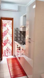 a kitchen with a refrigerator and a red rug at Studio with shared pool terrace and wifi at Sciacca in Sciacca
