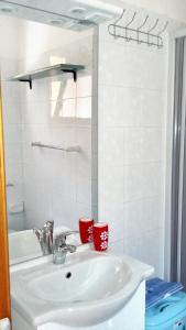 a bathroom sink with two red cups on it at Studio with shared pool terrace and wifi at Sciacca in Sciacca