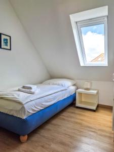 a bedroom with a bed and a window at Moin in Greetsiel