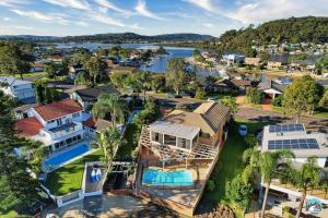an aerial view of a house with a lake at Aircabin - Woy Woy - Water Front - 6 Beds Lux Home in Daleys Point