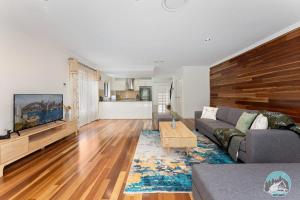 a living room with a couch and a table at Aircabin - Telopea - Sydney - 5 Beds Holiday House in Sydney