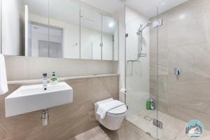 a bathroom with a toilet and a sink and a shower at Aircabin - Olympic Park - Cheerful - 3 Beds APT in Sydney