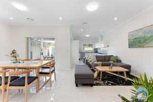 un soggiorno con tavolo e divano di Aircabin - Panania - Sydney - Cozy - 5 Beds House a Panania