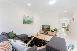 uma sala de estar com um sofá e uma mesa em Aircabin - Panania - Sydney - Cozy - 5 Beds House em Panania