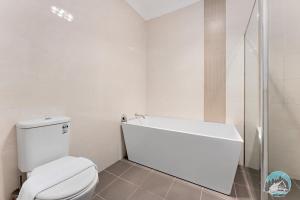 a white bathroom with a toilet and a shower at Aircabin - Panania - Sydney - Cozy - 5 Beds House in Panania +13 photos