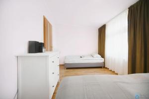ソポトにあるApartament Chopinのベッドルーム1室(ベッド1台、ドレッサー、テレビ付)