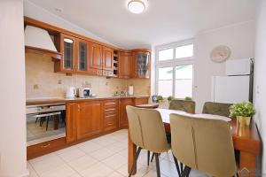 a kitchen with wooden cabinets and a table and chairs at Apartament Chopin in Sopot
