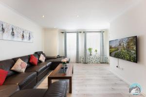 una sala de estar con un sofá y una mesa en Aircabin - Seven Hills - Lovely - 3 Beds Townhouse, en Blacktown