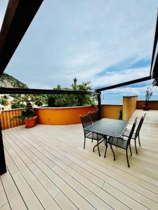 a patio with a table and chairs on a deck at Luxurious Monaco Flat: Stunning Views & Amenities in Monte Carlo