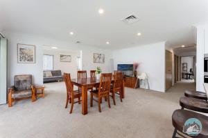 a dining room and living room with a table and chairs at Aircabin - Tuggerawong - Waterfront - 4 Beds House in Karraganbah