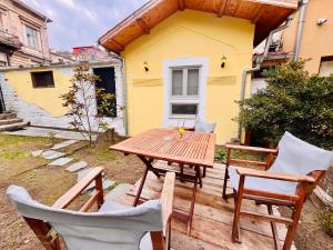 a wooden table and chairs in front of a yellow house at Balloon Boutique House, City Centre in Plovdiv