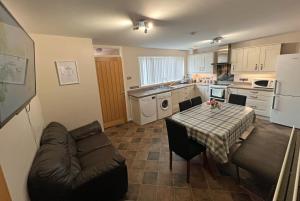 a kitchen with a table and a couch in a kitchen at 3 Bedroom House near city centre in Belfast