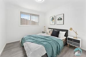 una camera da letto bianca con un letto e una finestra di Aircabin - Edmondson Park - 4 Beds Compy House a Prestons
