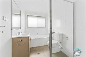 un bagno con vasca, WC e lavandino di Aircabin - Edmondson Park - 4 Beds Compy House a Prestons Altre 6 foto