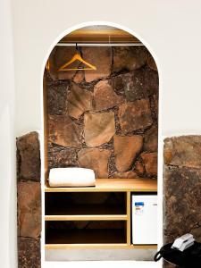 a room with a stone wall and a shelf at Villa Hortensia in Mucugê
