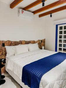 a bedroom with a bed with a blue and white blanket at Villa Hortensia in Mucugê