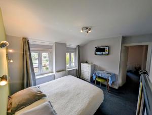 - une chambre avec un lit et un bureau dans l'établissement Logis Hôtel Le Beau Site, à Chambon-sur-Lac