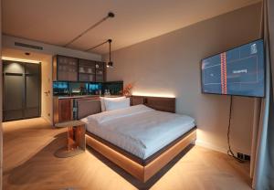 a bedroom with a bed and a monitor on the wall at The Zipper Hotel und Apartments in Düsseldorf