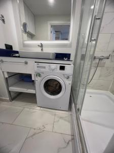 uma máquina de lavar roupa na casa de banho com um espelho em Orbi City Hotel em Batumi