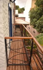 a balcony with a wooden table and a wooden railing at Villa Hortensia in Mucugê