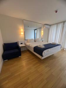 um quarto com uma cama grande e uma cadeira em Orbi City Hotel em Batumi