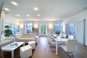 d'un salon avec des meubles blancs et des fenêtres. dans l'établissement Appartement Francis F. Copolla, à Cannes