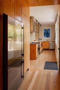 une cuisine avec un réfrigérateur en acier inoxydable et du parquet dans l'établissement 'Wietenah=' - Perfectly renovated historic cottage, à Hobart