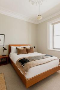 une chambre avec un grand lit et une fenêtre dans l'établissement 'Wietenah=' - Perfectly renovated historic cottage, à Hobart