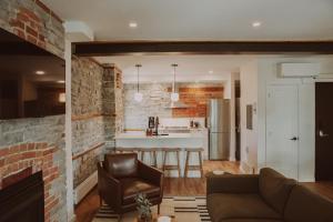 a kitchen and living room with a brick wall at The Colby House - Downtown Kingston in Kingston