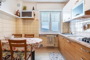 a kitchen with a table and a sink at House Cuel Milena Folgaria - Yellow in Folgaria