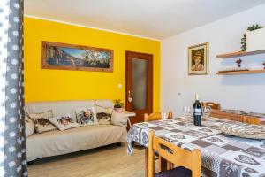 ein Wohnzimmer mit einem Tisch und einem Sofa in der Unterkunft House Cuel Milena Folgaria - Yellow in Folgaria