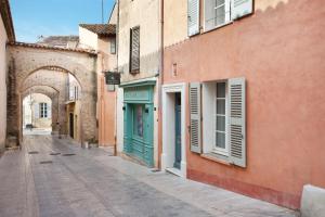 an alley in an old town with an archway at Maison Misericorde in Saint-Tropez