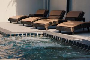 a group of chairs and a pool in a building at Peppery Hills in Chiang Mai
