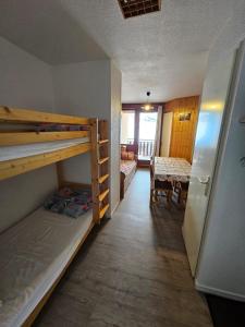 a room with two bunk beds and a dining room at La Croix du Sud in Valmeinier