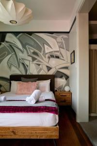 霍巴特'Elizabeth House=' in prime Hobart CBD location的一间卧室配有一张带花卉图案墙壁的床