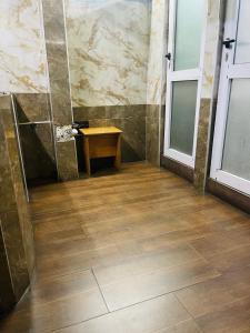 a bathroom with a shower and a wooden floor at Niagara Hotel in Accra