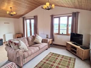a living room with a couch and a tv at Lomond 5 with Private Hot Tub - Fife - Loch Leven - Lomond Hills - Pet Friendly in Kelty