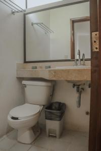 a bathroom with a toilet and a sink and a mirror at Hotel Manzana Blanca 5th Avenue in Playa del Carmen