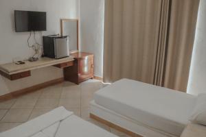 ein Hotelzimmer mit einem Bett und einem TV in der Unterkunft Hotel Manzana Blanca 5th Avenue in Playa del Carmen