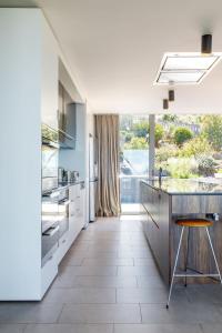 a kitchen with white appliances and a large window at Architectural glass house with ocean views in Taroona