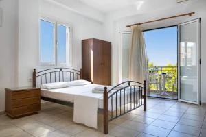 a bedroom with a bed and a large window at Αngelika studios in Argostoli